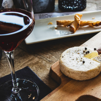 Photographie d'un apéro, verre de vin et fromage sur plateau